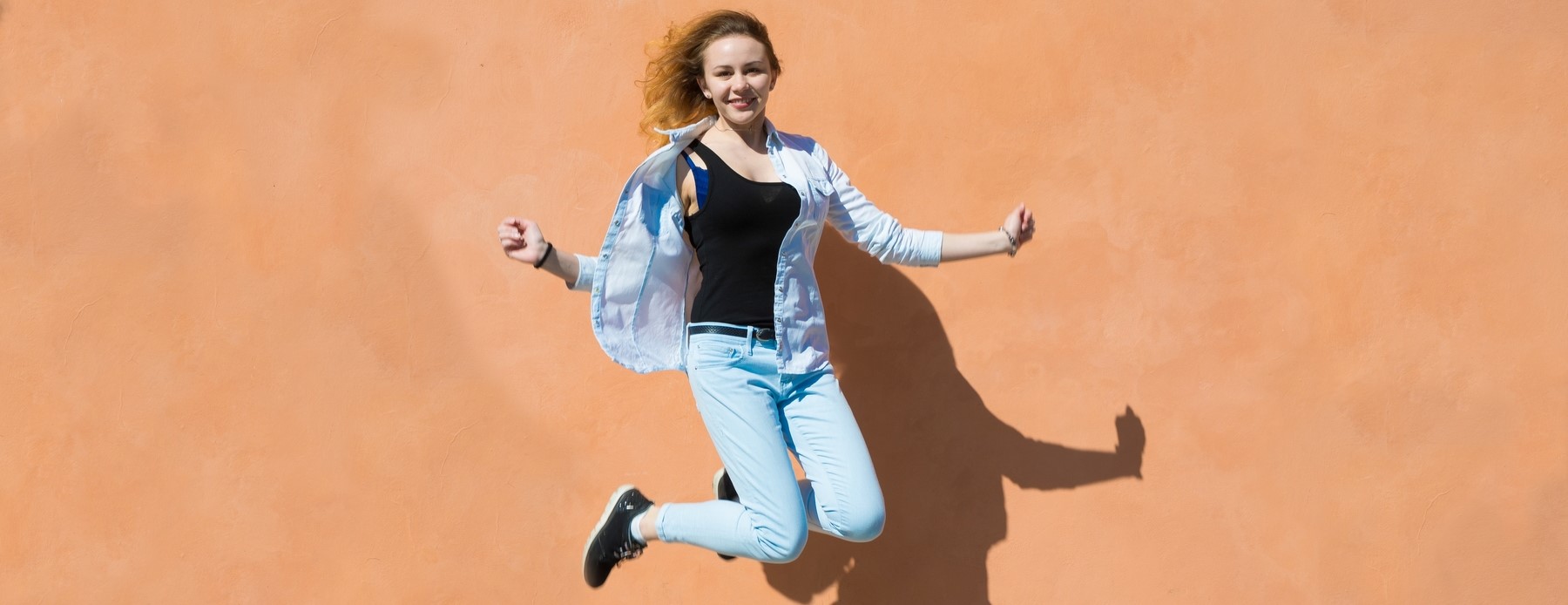 young woman jumping on orange background 2023 11 27 05 19 22 utc 1 2 - W tym artykule zajmę się jednym z tych pytań. Poruszę temat wystawiania ocen za brak pracy domowej. Jest to kolejna praktyka, która nie jest do końca zgodna z prawem.